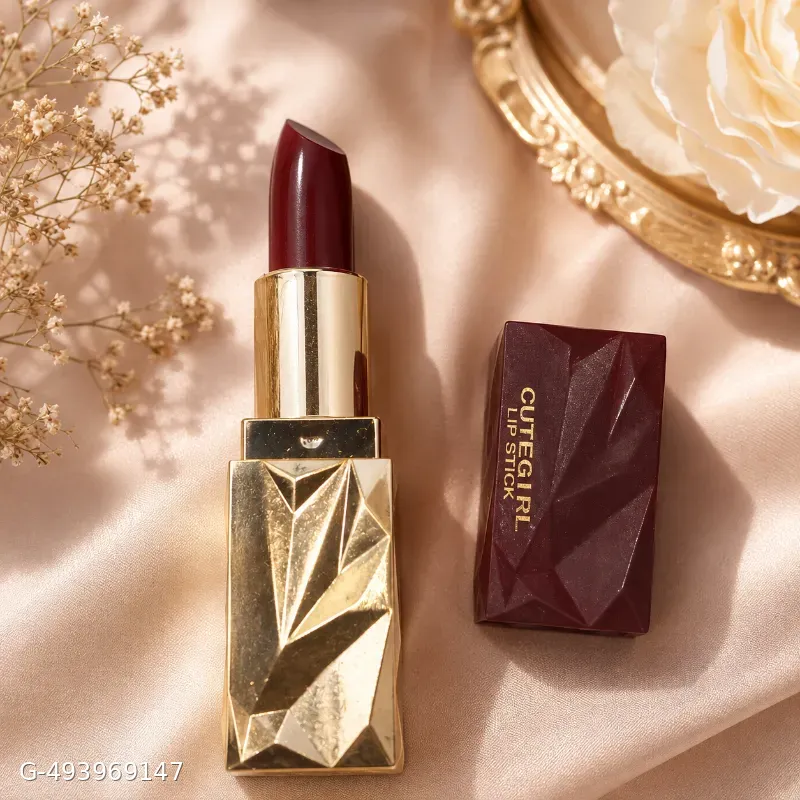 The image displays an aesthetic arrangement of a deep maroon lipstick with a faceted, geometric gold base and matching cap labeled "CuteGirl Lip Stick."